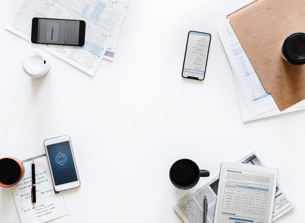 mesa com celulares e planilhas